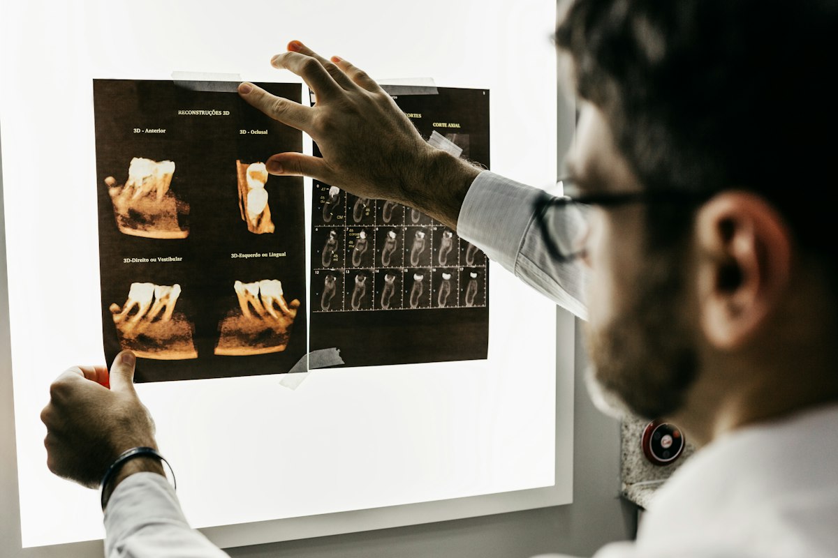 A dentist reviewing dental radiographs on a light box