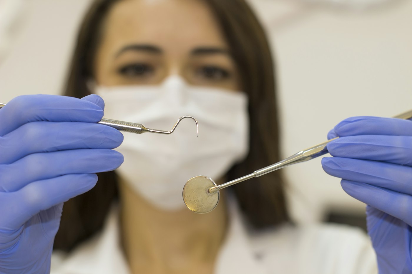 A dental assistant holding examination instruments